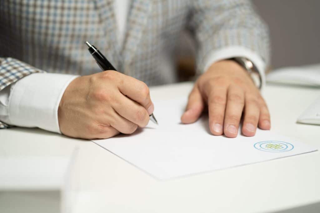 main dun homme ecrivant une lettre de recommandation